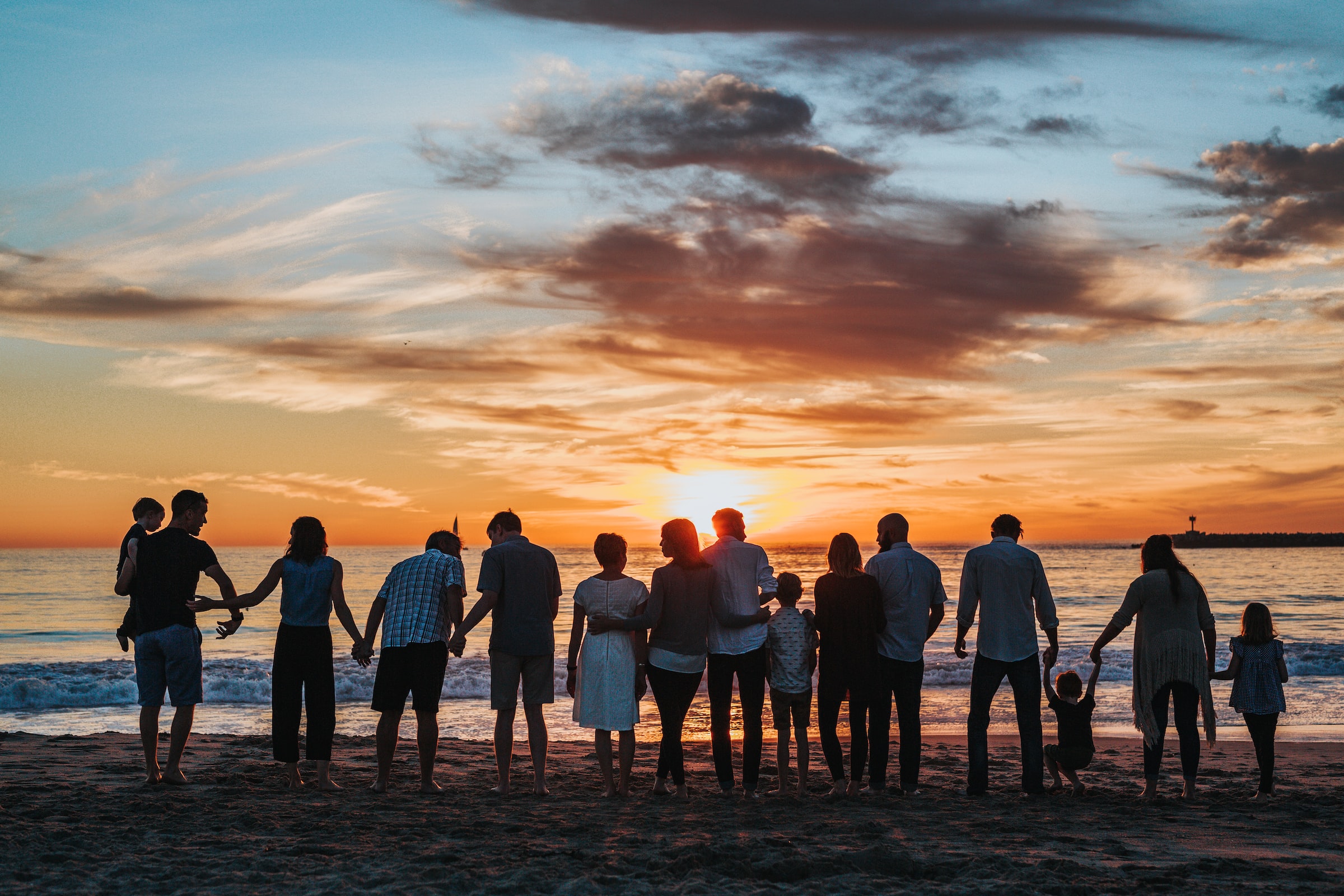 Photo of people on the beach at sunset
